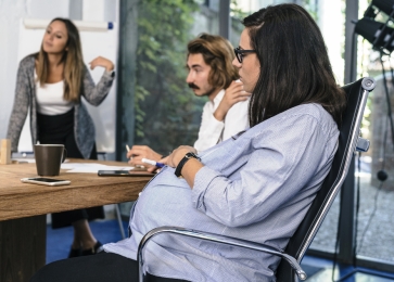 Pregnant woman discusses strategy with her research team 
