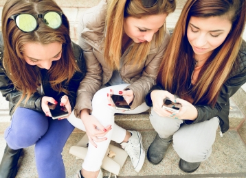 Teen girls using phone apps together