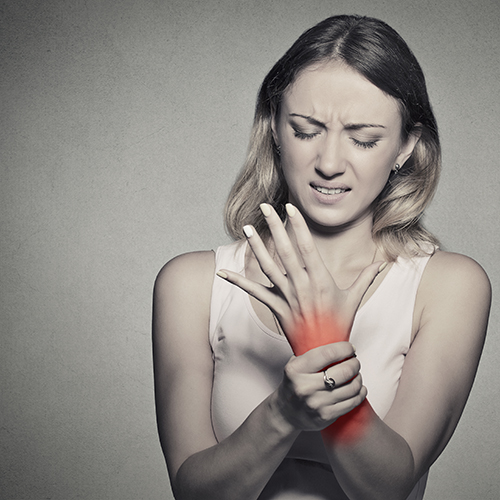 young woman holding her wrist in pain