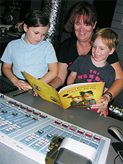 woman reading book to children