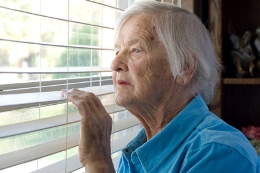 Elderly woman looking out window