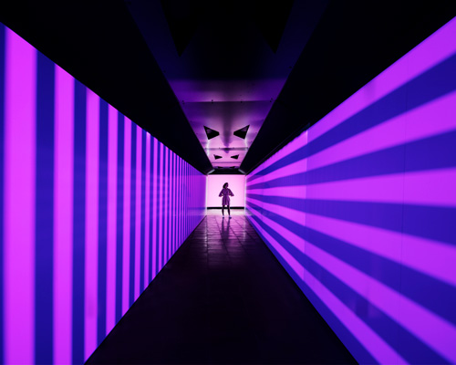 Person standing at the end of an illuminated tunnel