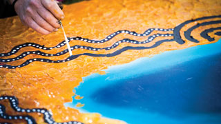 This artwork is one of four pieces created during UniSA’s Reconciliation Week celebrations in 2014. Aboriginal artist Chris Ackland worked with UniSA students to create a piece at each metropolitan campus. Together, the four pieces form a larger work depicting South Australia through the use of traditional Aboriginal dot painting and other contemporary techniques. Photo: Juan Photography.