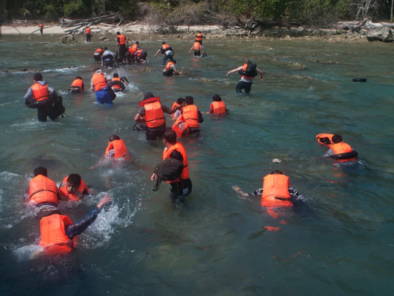 Refugees wading through the sea to the shore