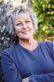 Germaine Greer leaning against a gum tree