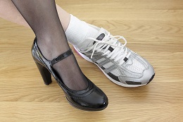 Woman wearing work shoe and gym shoe