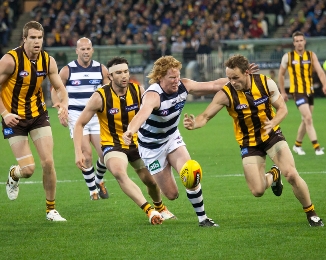 Australian rules football players vie for the ball