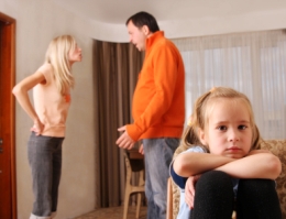 Child with parents fighting in the background 