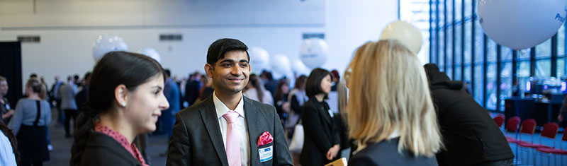 Well dressed UniSA student networking with two industry partners