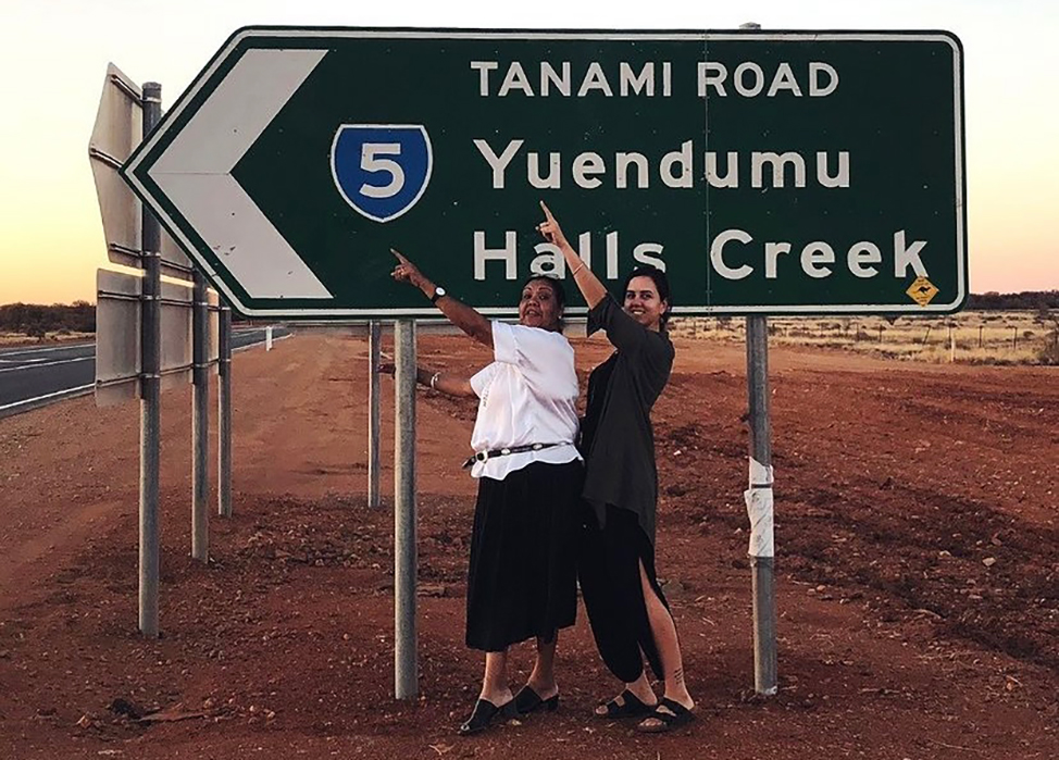 Kimberley Hunter under a sign for Halls Creek