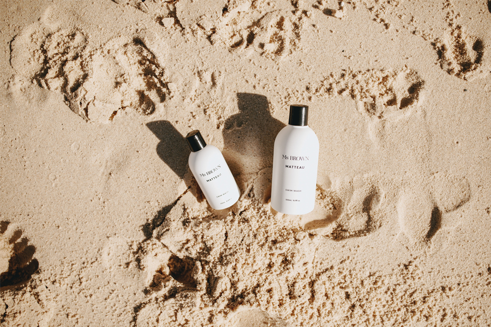 Two bottles of Ms Brown Swim Wash lying in the sand