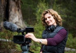 Film maker Heather Kirkpatrick standing next to her camera. 