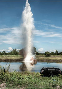 A plume of water shoots into the sky after liquid explosives are detonated underwater