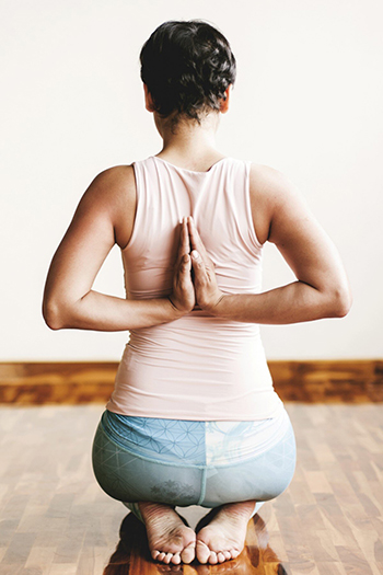 Back view of a woman in a kneeling yoga position
