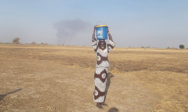 Abok Dau carrying water from a dirty water source