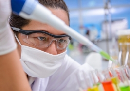 Female researcher using a large pipette with test tubes