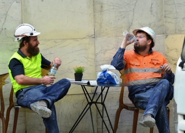 Two construction workers talk over lunch