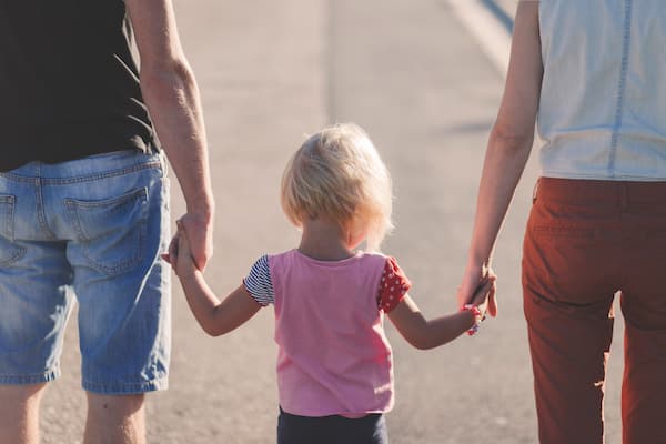 Girl holding parents hands.jpg