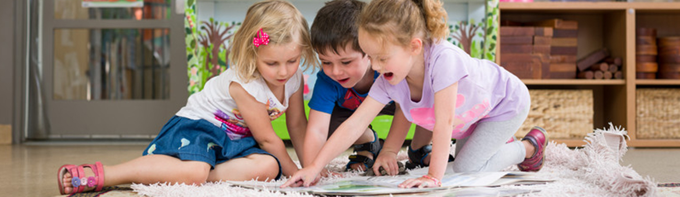 Three children reading a book