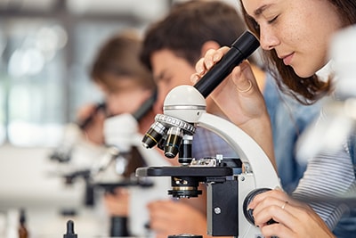 Student looking through a microscope, shutterstock 1841011750