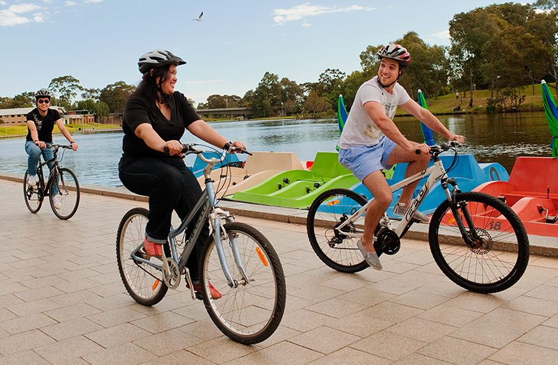 People riding bikes along a riverbank