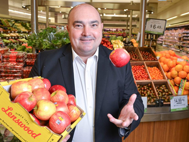 Franklin Dos Santos tossing an apple in the fruit and vegetable section of Foodland