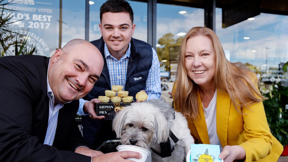 Franklin Dos Santos front of store treating a pooch to a drink