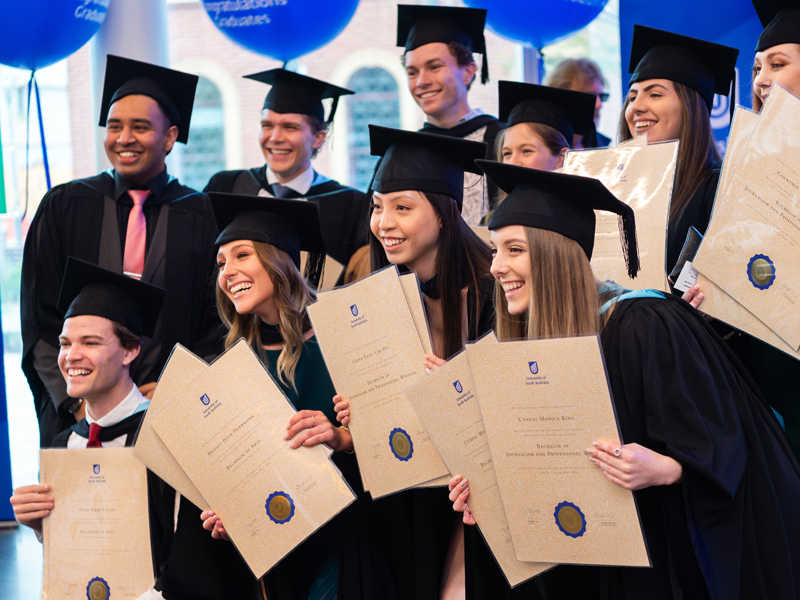 Students holding their parchments after graduation