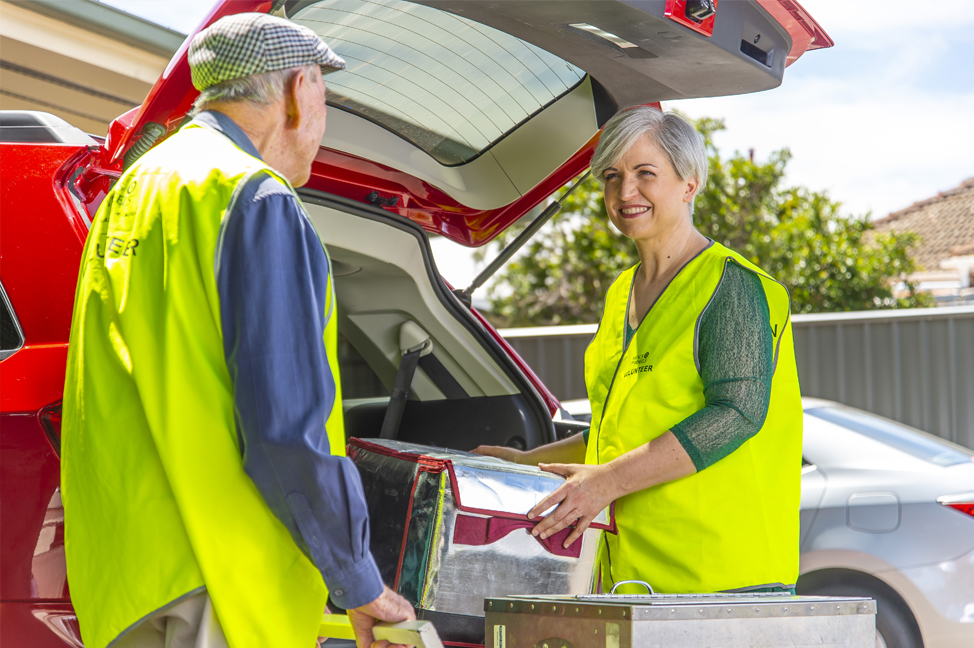 Sharyn delivering meals with a volunteer