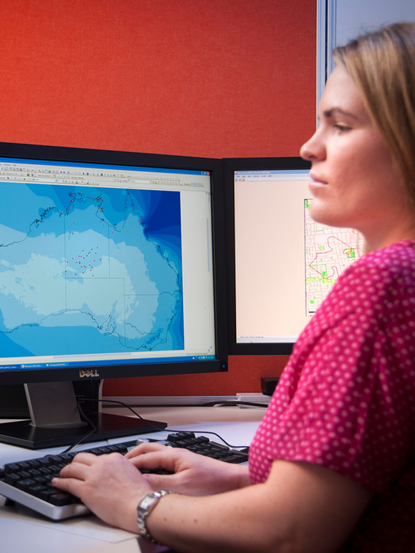 A researcher working in front of several screens