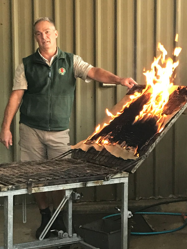 Ian Tanner, Department for Environment and Water fire manager for the Adelaide-Mt Lofty Region using a burn table to explain fire behaviour to students. 