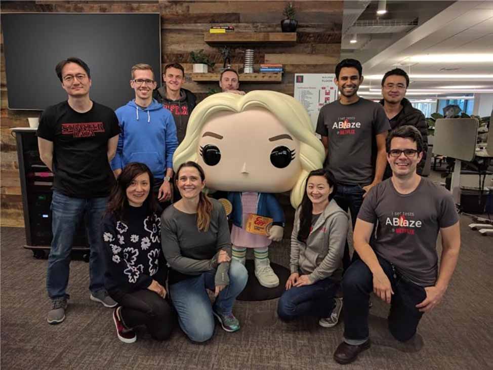 Phillipa (bottom row, second to left), with a Stranger Things FUNKO Pop! Figurine of Eleven, and her former Experimentation Platform team that facilitate the many A/B tests and help Netflix decide what the best experience is for users. 
