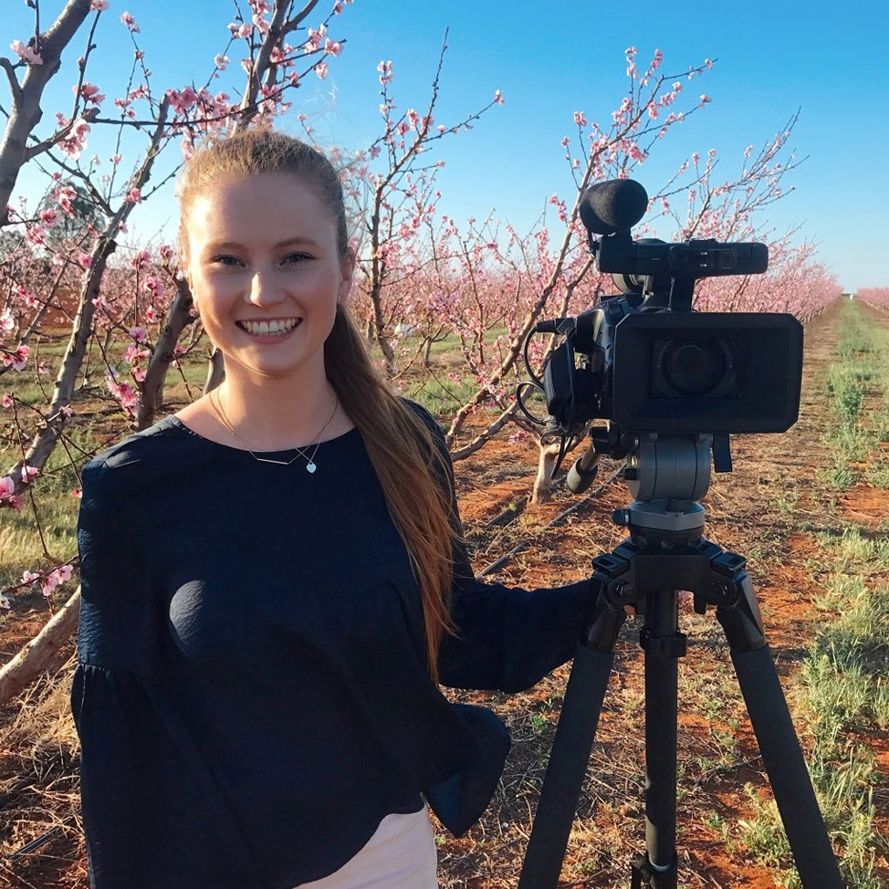 Brittany Evins, Journalist at ABC News, in a blossoming orchard