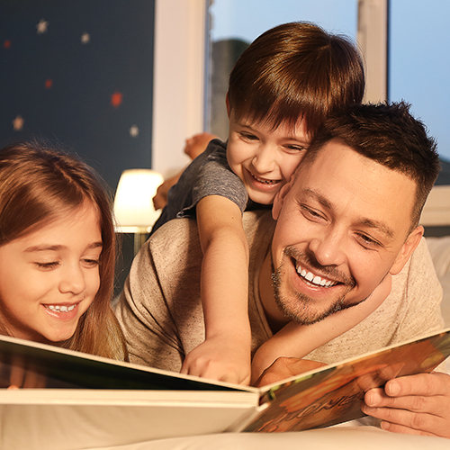 Dad reading a book to his two children