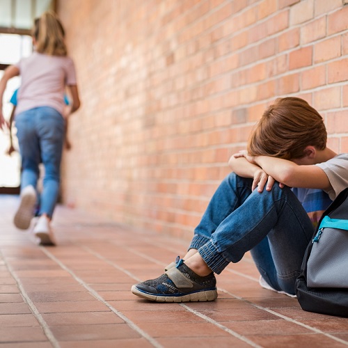 Boy with his head resting on his arms. 