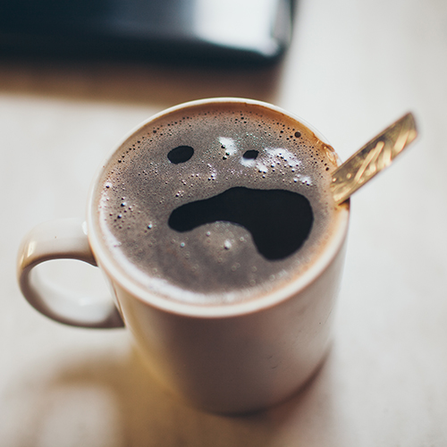 sick face on froth of coffee