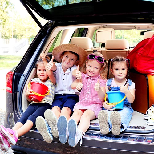 kids in car boot excited about family road trip