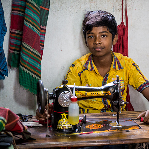 child working on sewing machine