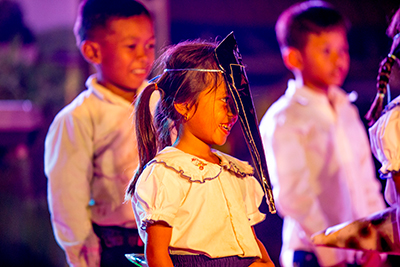 Children dressed as mosquitoes for a drama performance in a Cambodian village. Photo by Nicky Almasy.