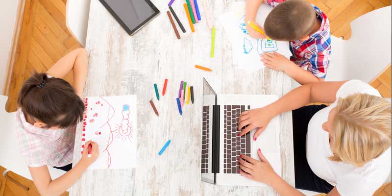 Mother working at home with kids 