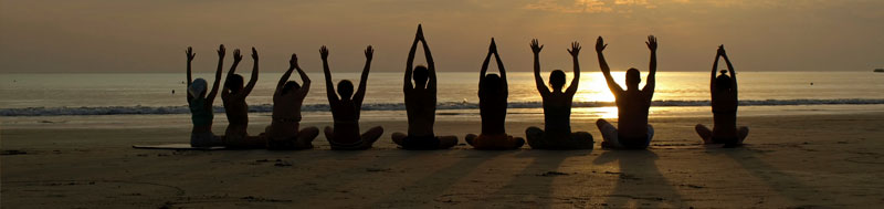 People on doing yoga on the beach