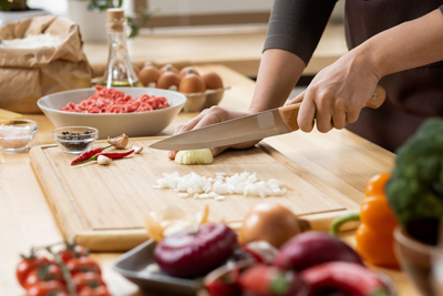 Cutting up onion on chopping board. Photo: Shutterstock